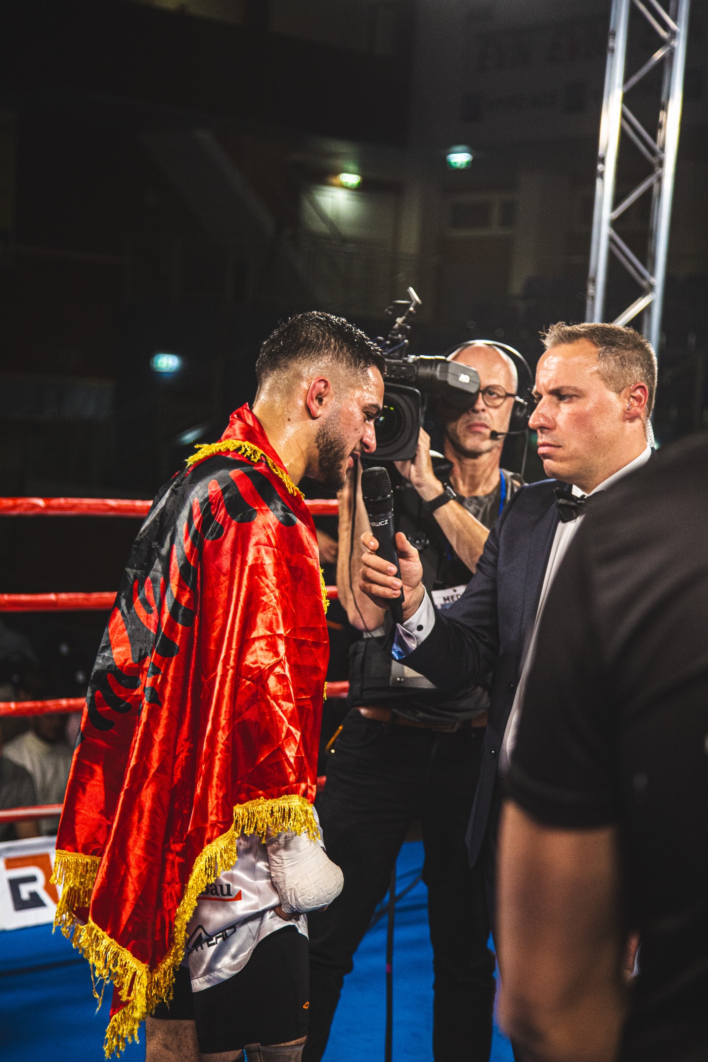 Argjent Shala after a fight, draped in the Albanian flag